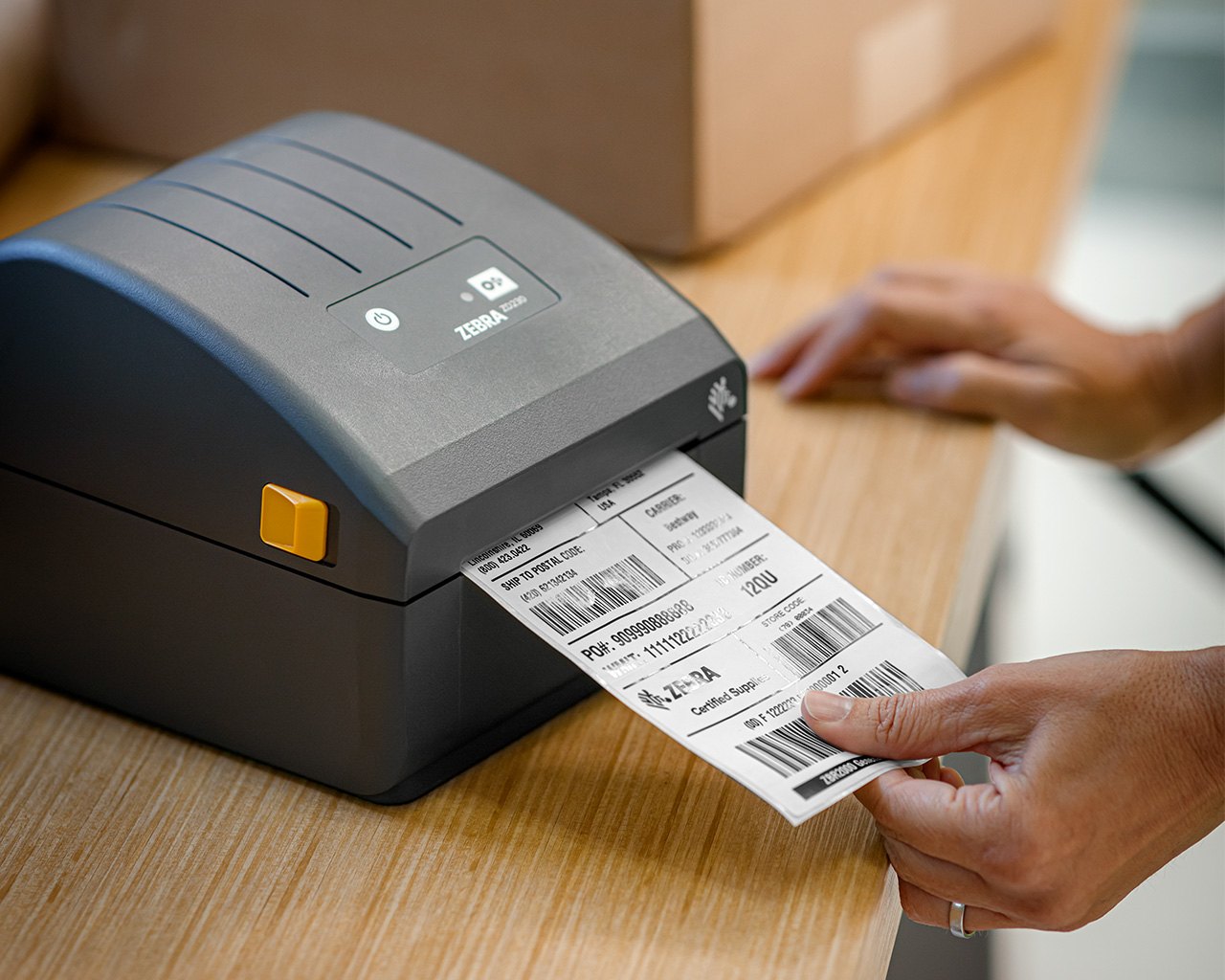 Desktop barcode printer printing shipping labels at a packing workstation