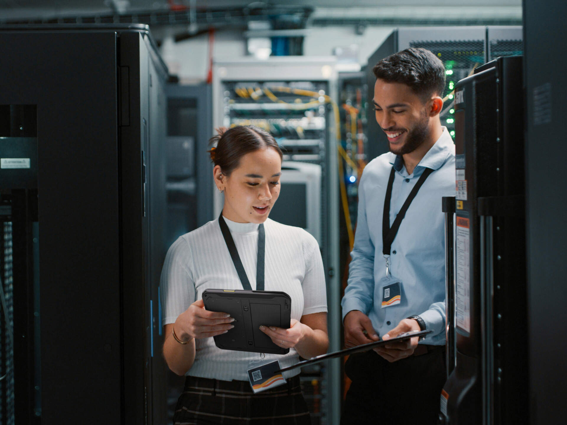Asset management team checking equipment data with a mobile device in a server room