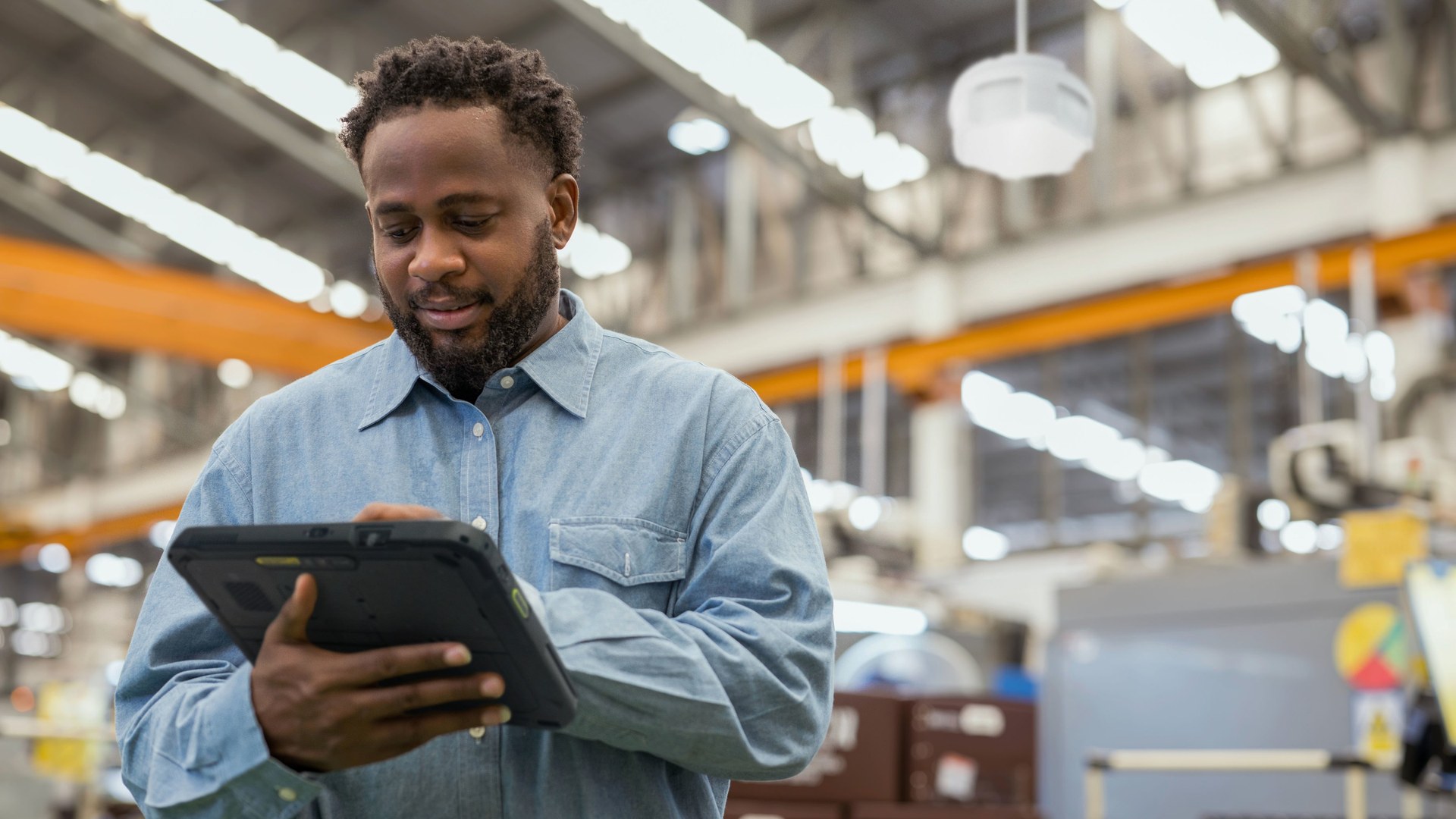 Employee using a rugged tablet while inspecting an industrial facility