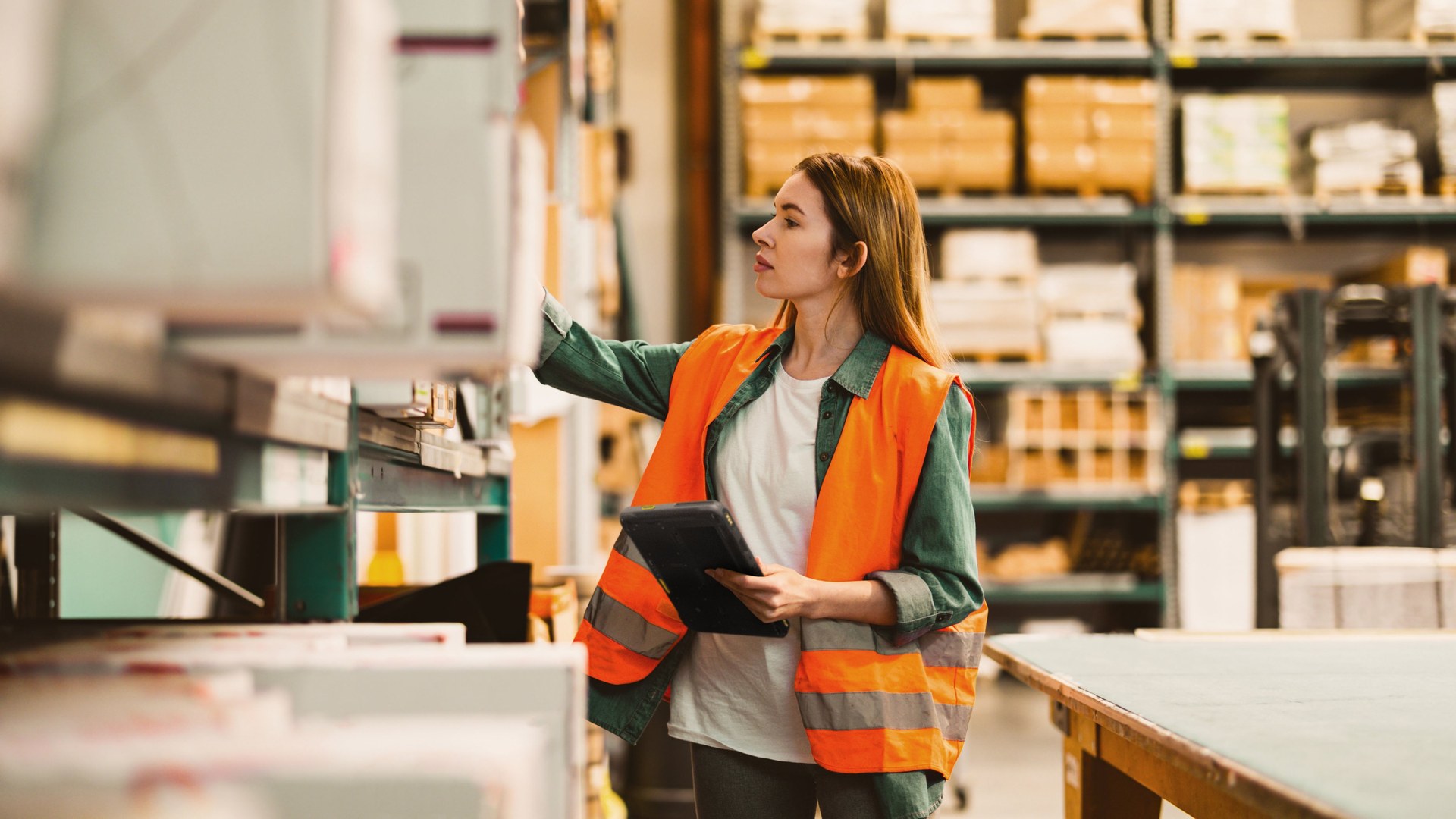Store or stockroom worker checking shelf inventory with a mobile device