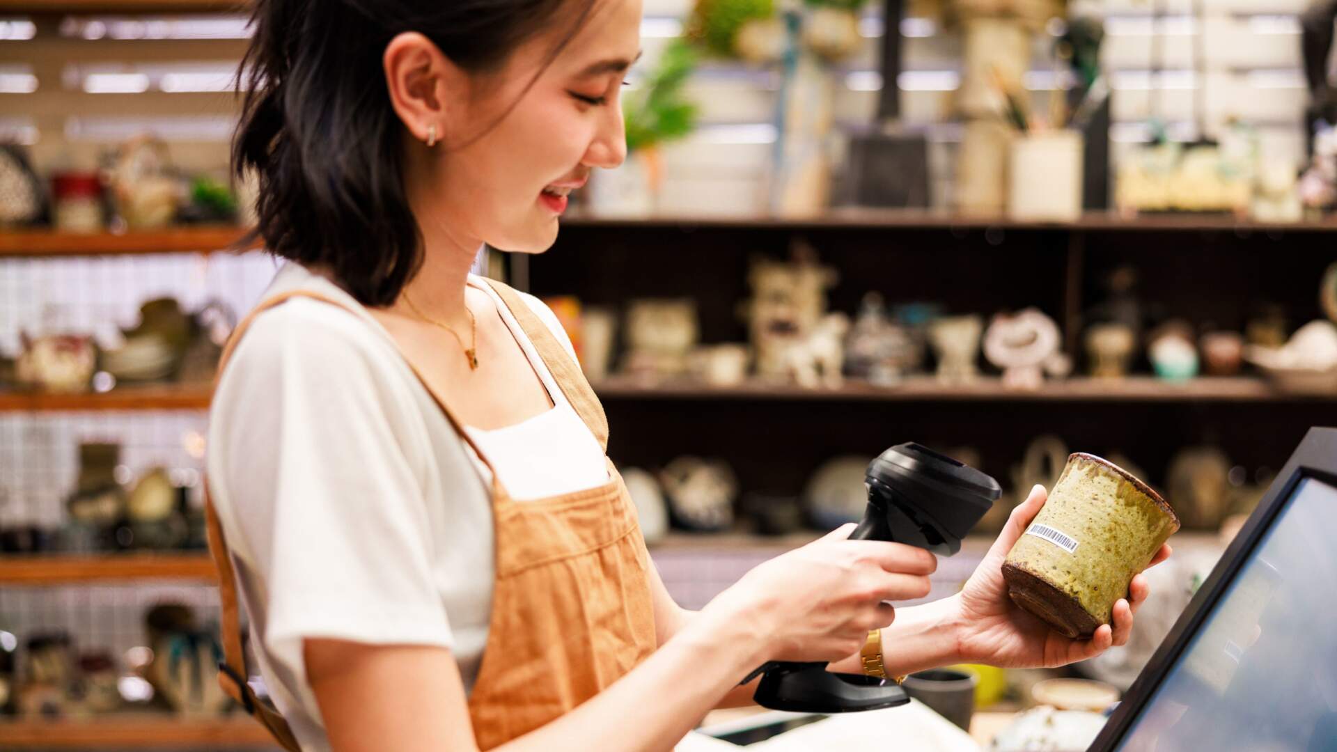 香港零售店員在收銀位置使用手持條碼掃描器