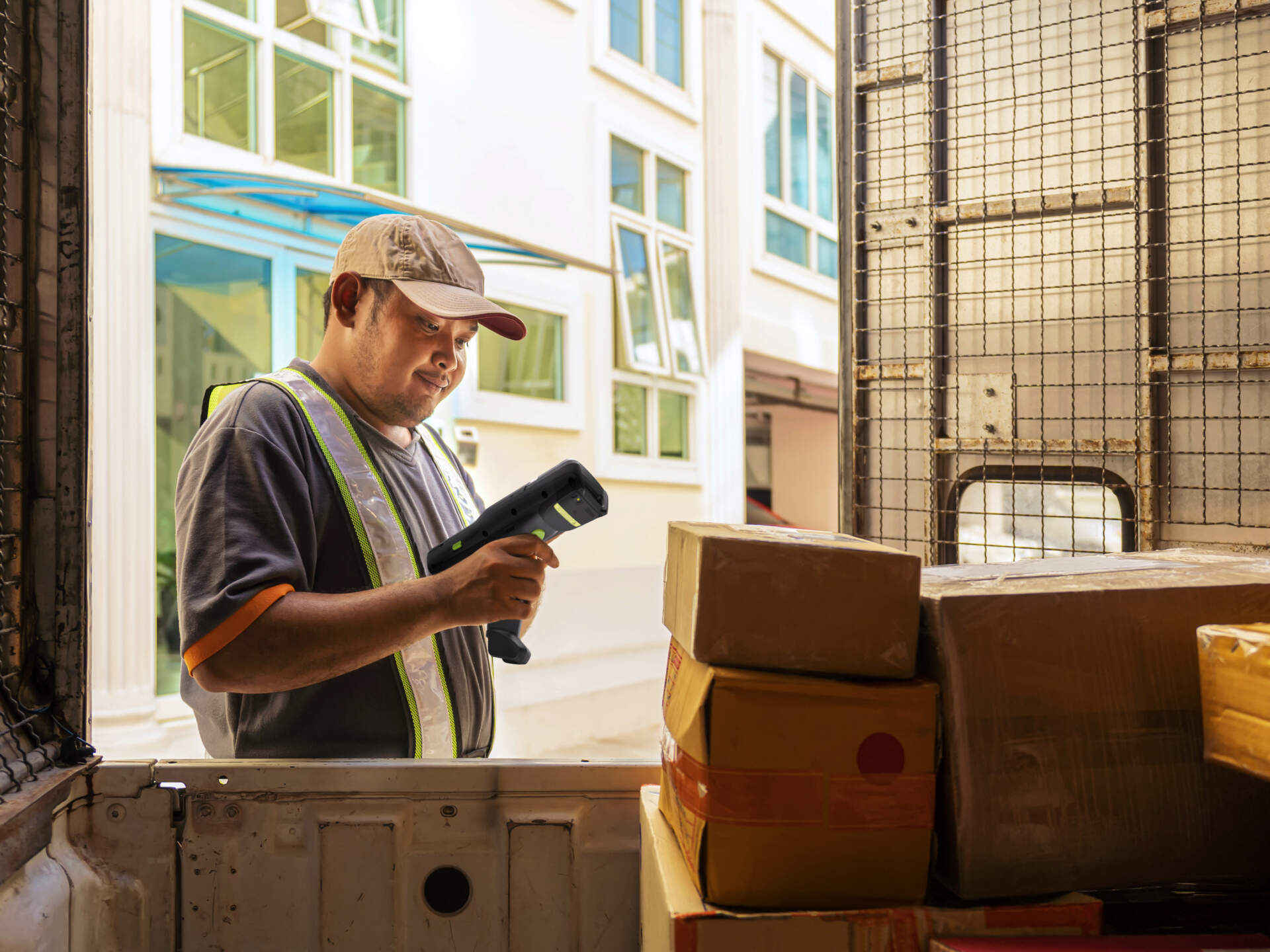 Logistics worker scanning a parcel before dispatch and checking delivery transaction data