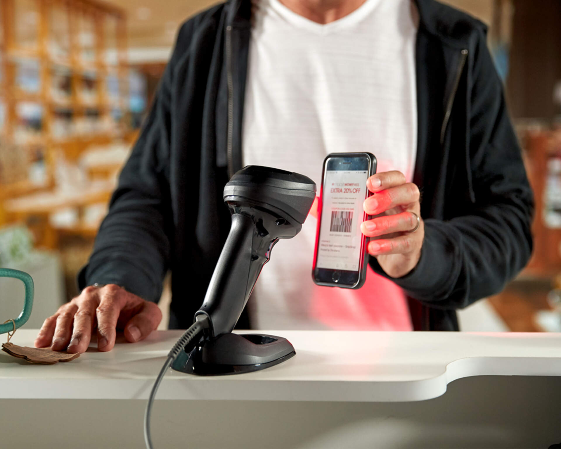 Hands-free counter scanner reading a barcode displayed on a phone