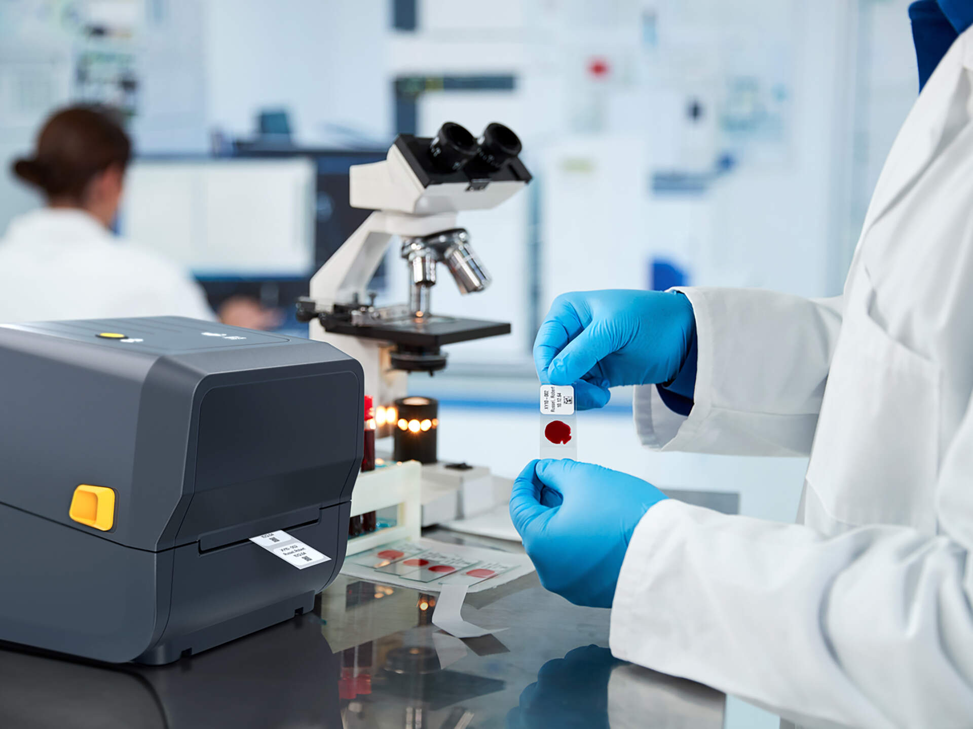 Laboratory operator inspecting a small printed identification label