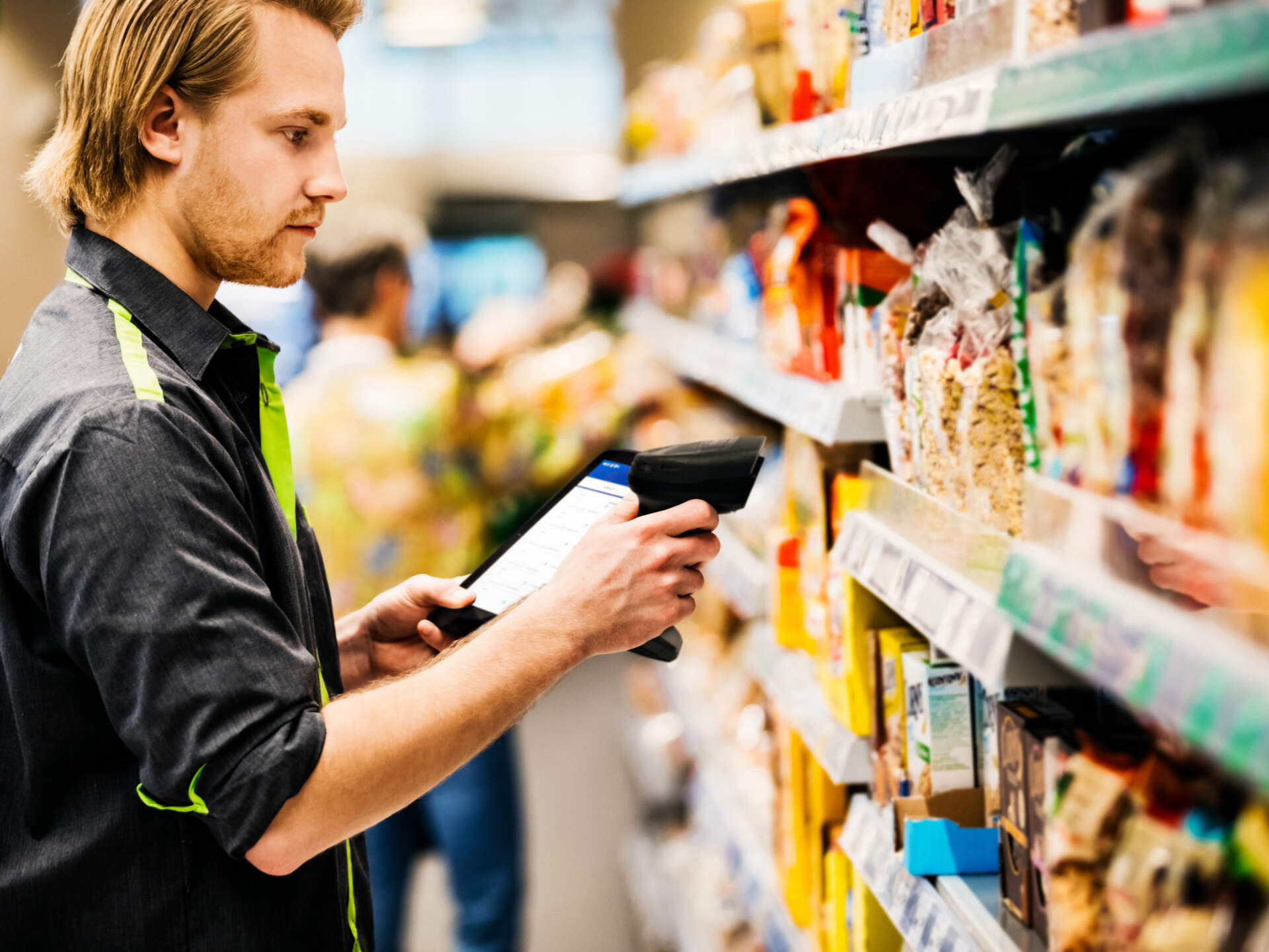 Retail employee scanning shelf stock with a handheld device